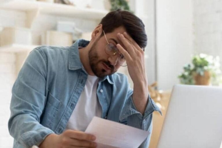 Image d'un homme pensif et dépressif après avoir reçu une notification de saisie sur compte bancaire sans avertissement